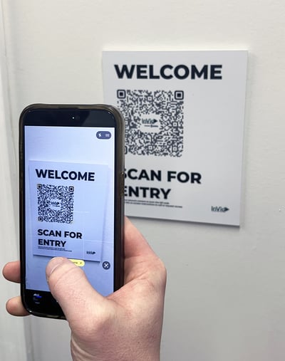 Visitor scanning an INVID-QR plate at a building entrance